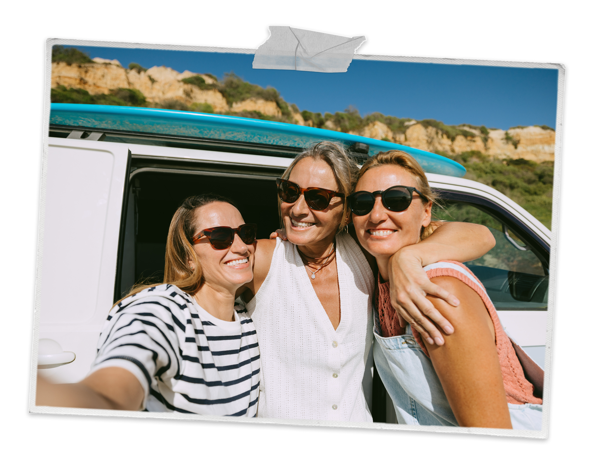 Friends smiling in front of camper van on their travels.