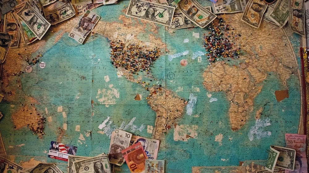 Map of the world with money and pins around it