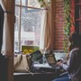A woman sat in a coffee shop using a laptop.