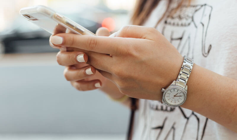 A close up of a woman's hands as she's using a mobile phone