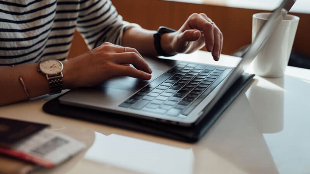 Woman using her phone and laptop