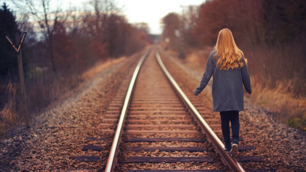 Woman walking on railway tracks | Wealthify