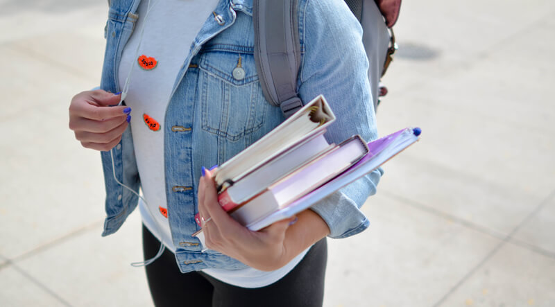 Student holding books | Wealthify