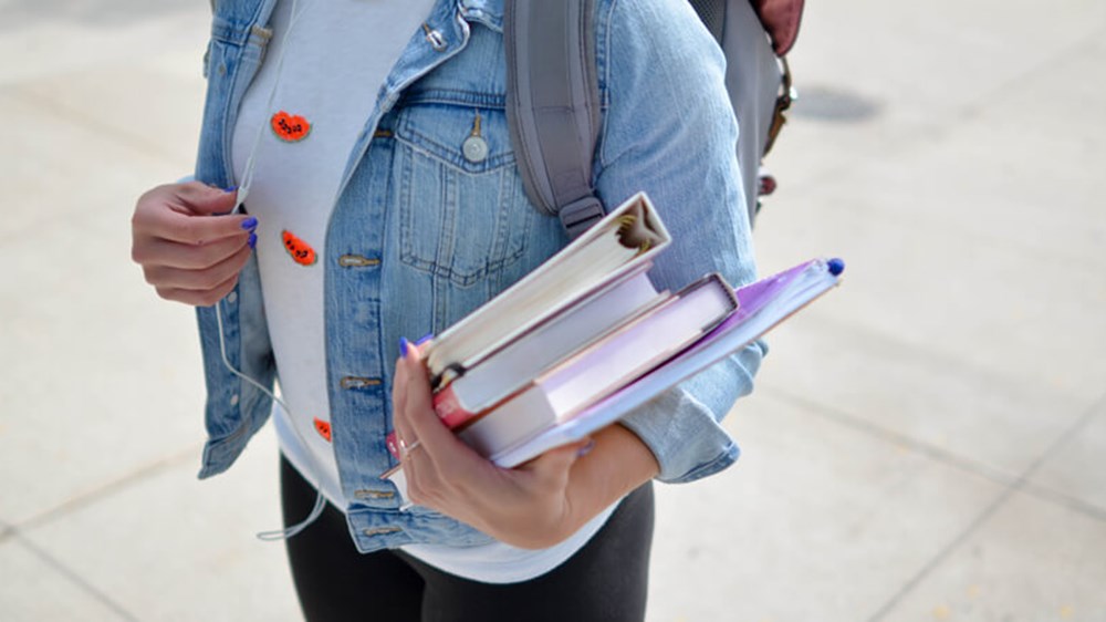 Student holding books | Wealthify