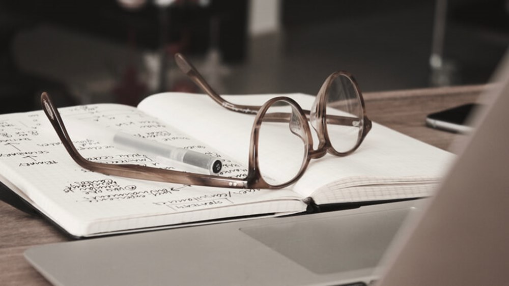 Notepad and glasses on table | Wealthify
