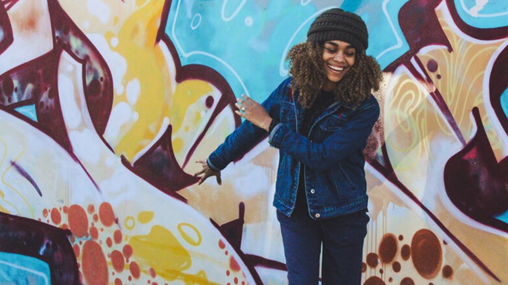 Woman smiling and street art | Wealthify