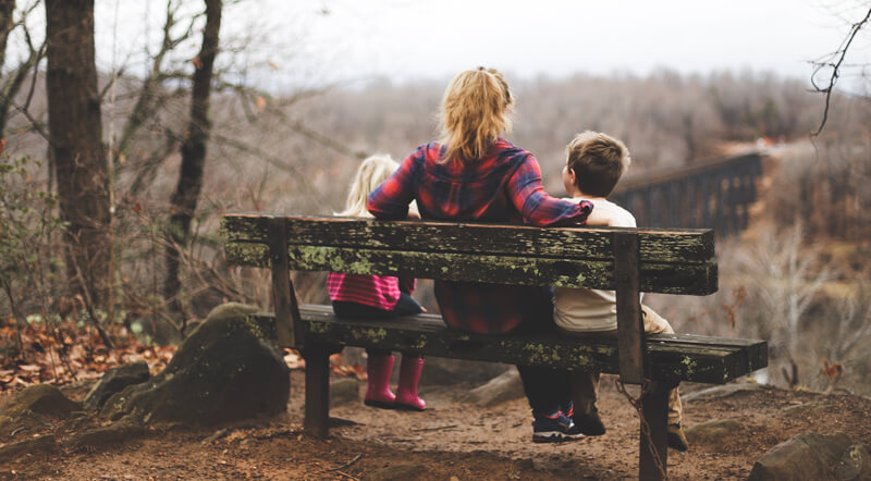 Mum with children sat on a bench | Wealthify