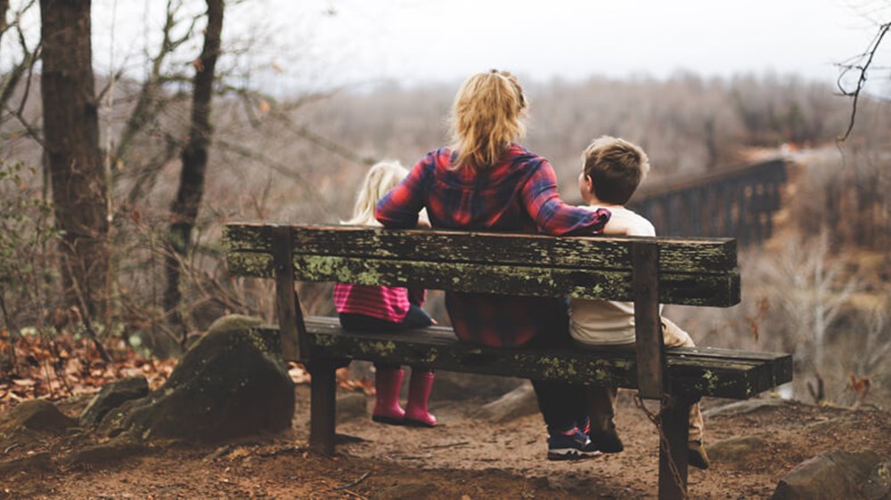 Mum with children sat on a bench | Wealthify