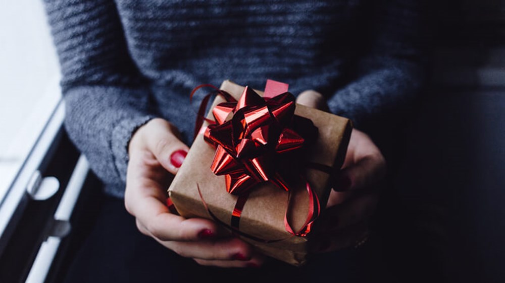 Person holding present | Wealthify
