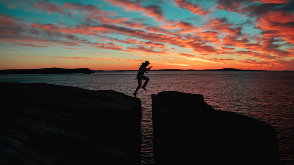 Man jumping over and sunset | Wealthify