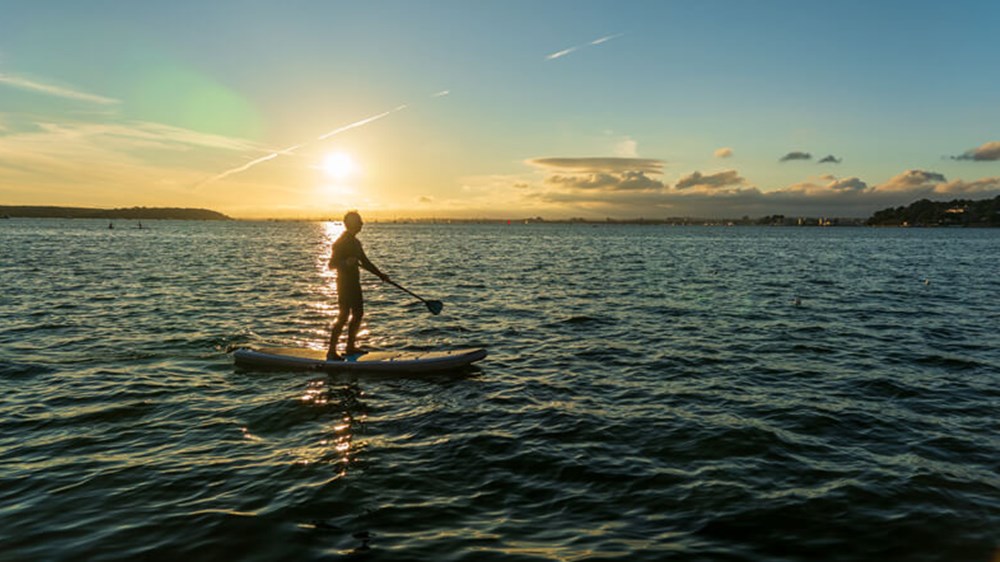 Paddleboard at sunset | Wealthify