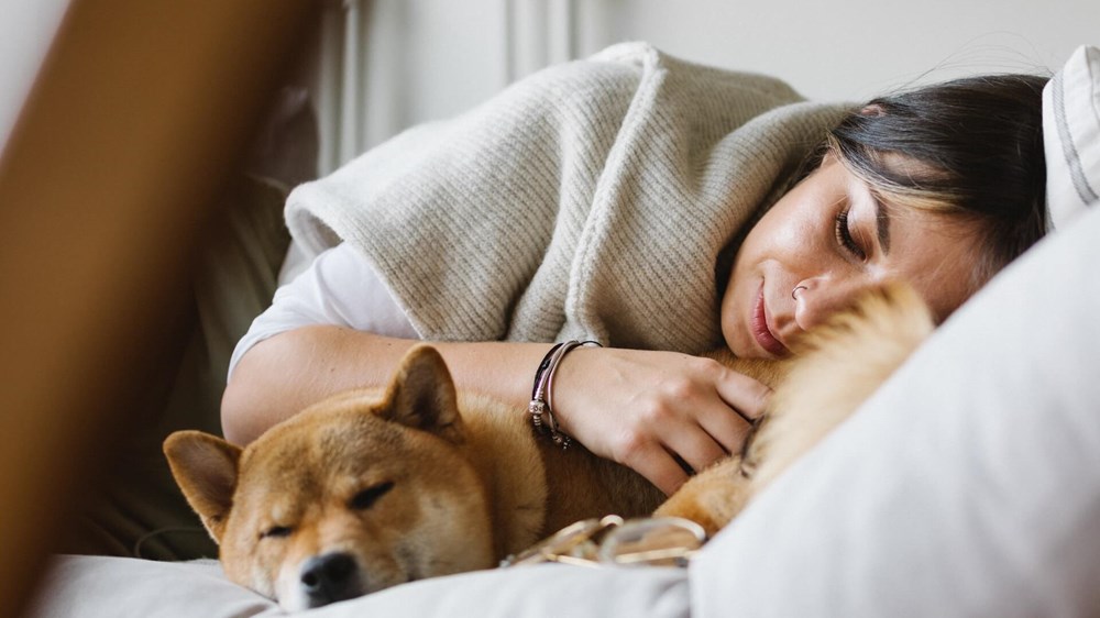 Woman sleeping with dog