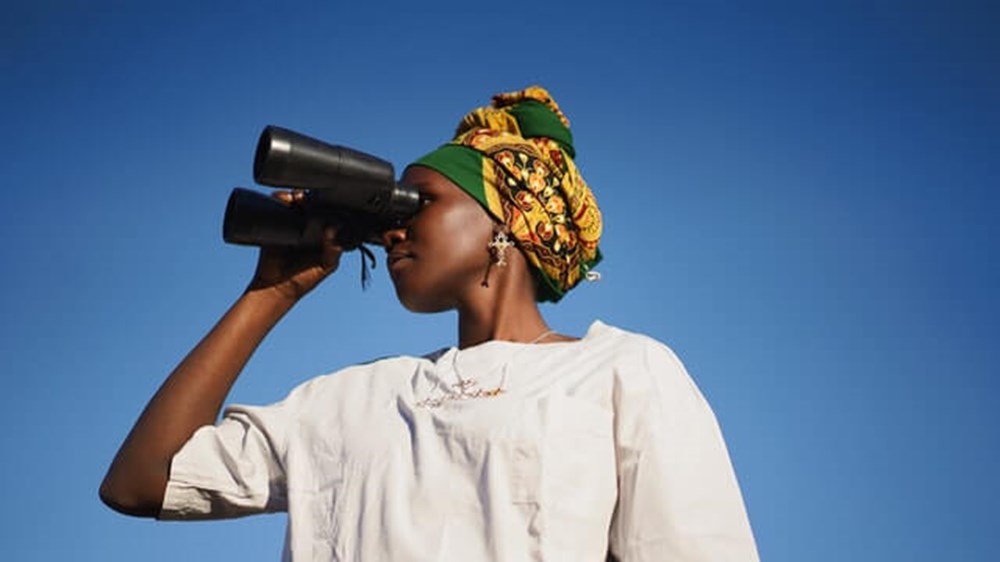 woman looking through binoculars | wealthify.com