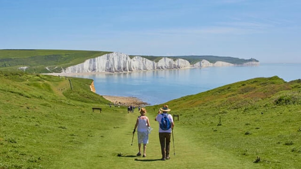 couple walking along the English coast | Wealthify.com