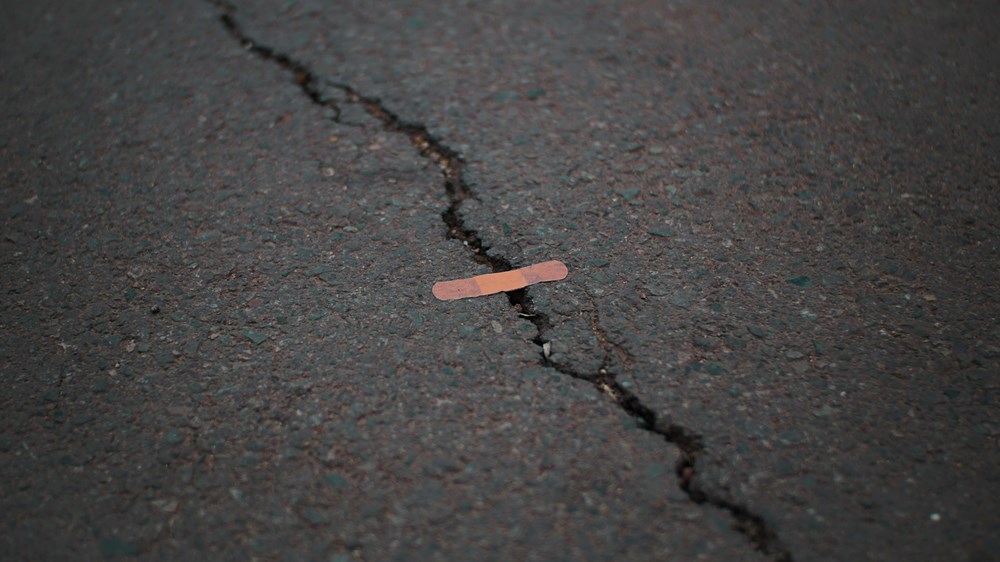 crack in the pavement patched with a bandaid | Wealthify.com