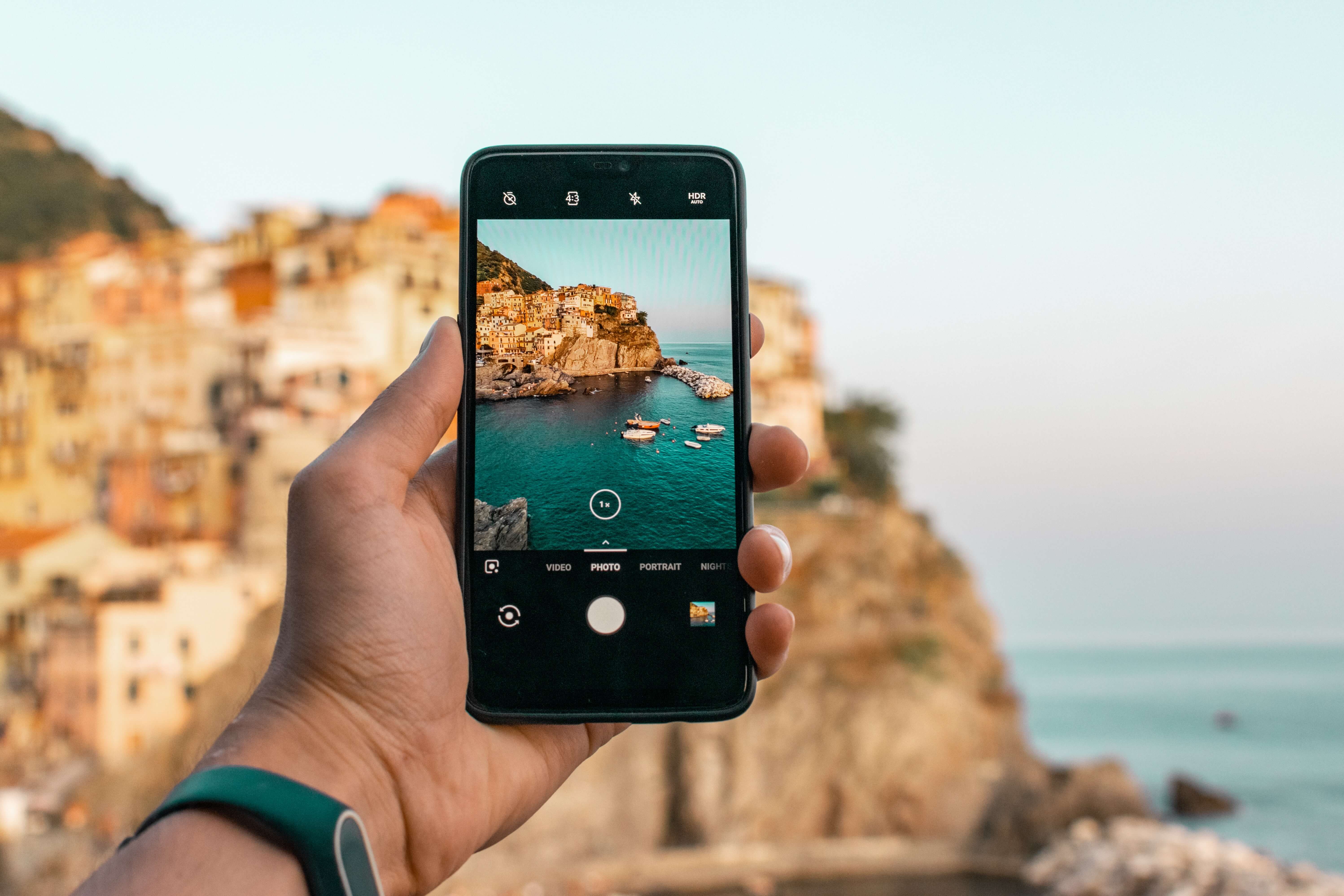 Person taking photo of cliffs and beach on a mobile phone