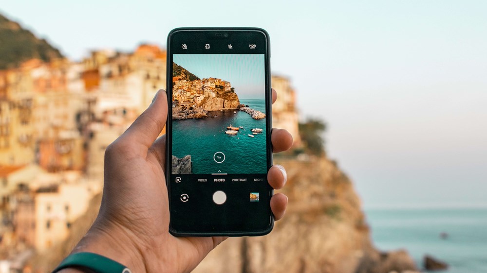 Person taking photo of cliffs and beach on a mobile phone