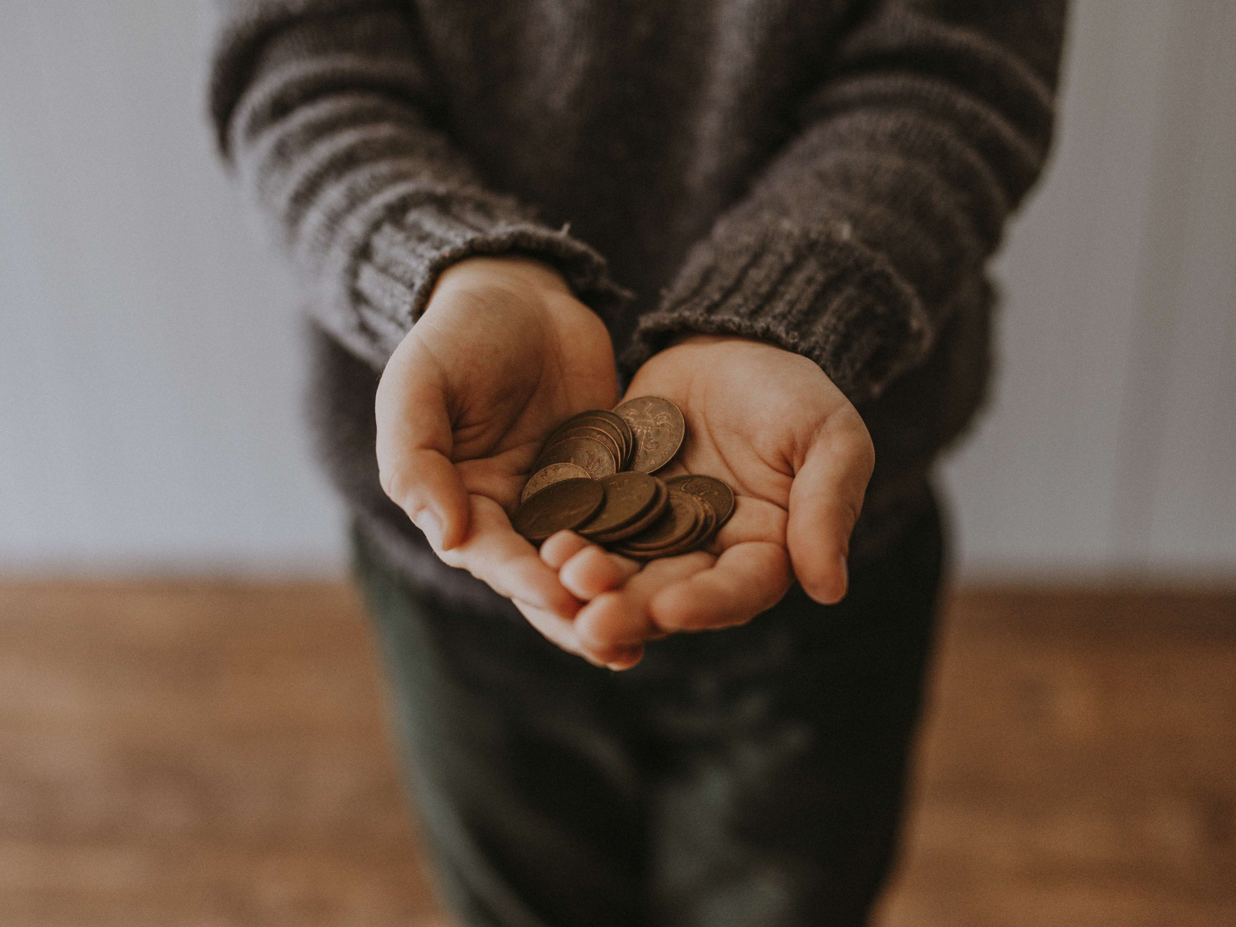 Child holding out coins in hand