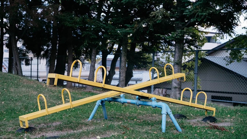 Two yellow seesaws one facing up the other down | Wealthify.com