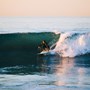 Man crouched on surfboard while surfing