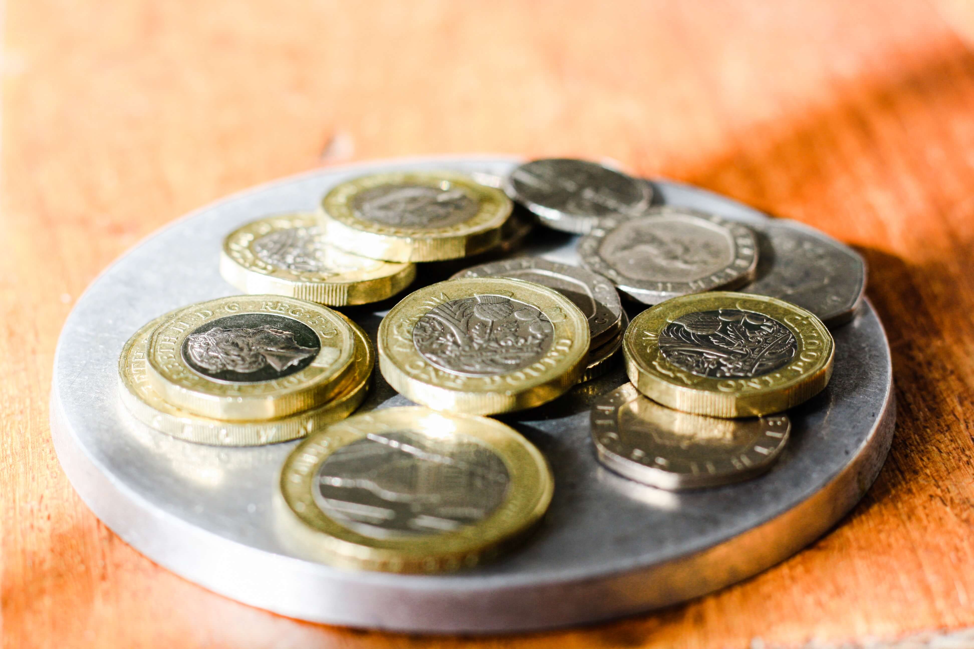 Image of various British coins on a silver dish