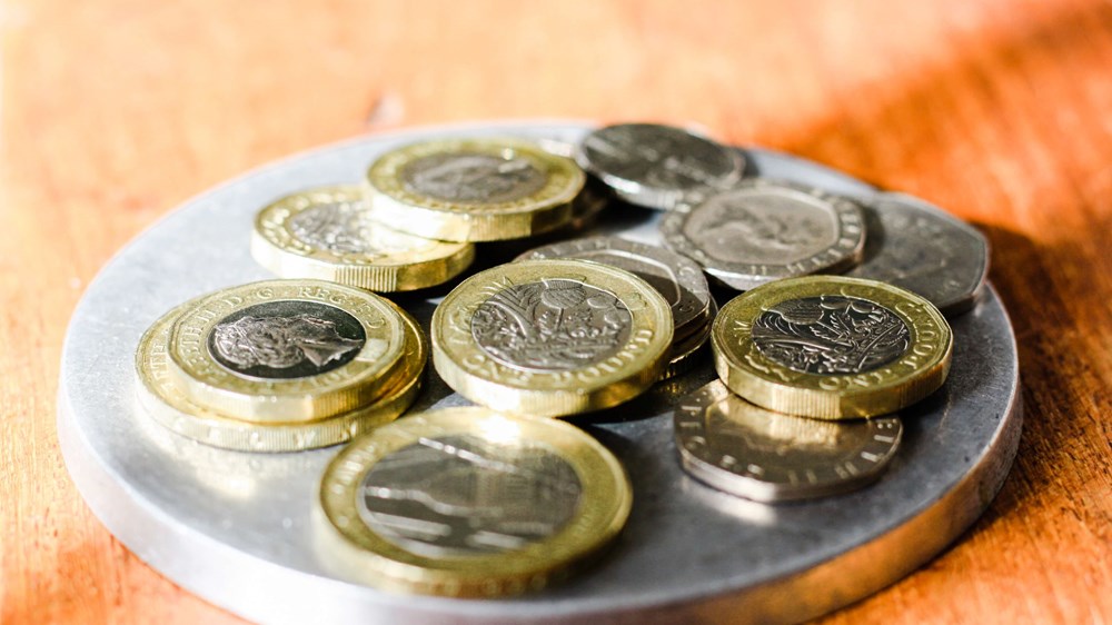 Image of various British coins on a silver dish