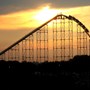 Image of a rollercoaster silhouette against a sunset and yellow sky