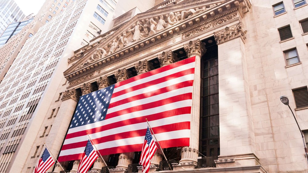 Large American flag on pillars of a building on New York's Wall Street