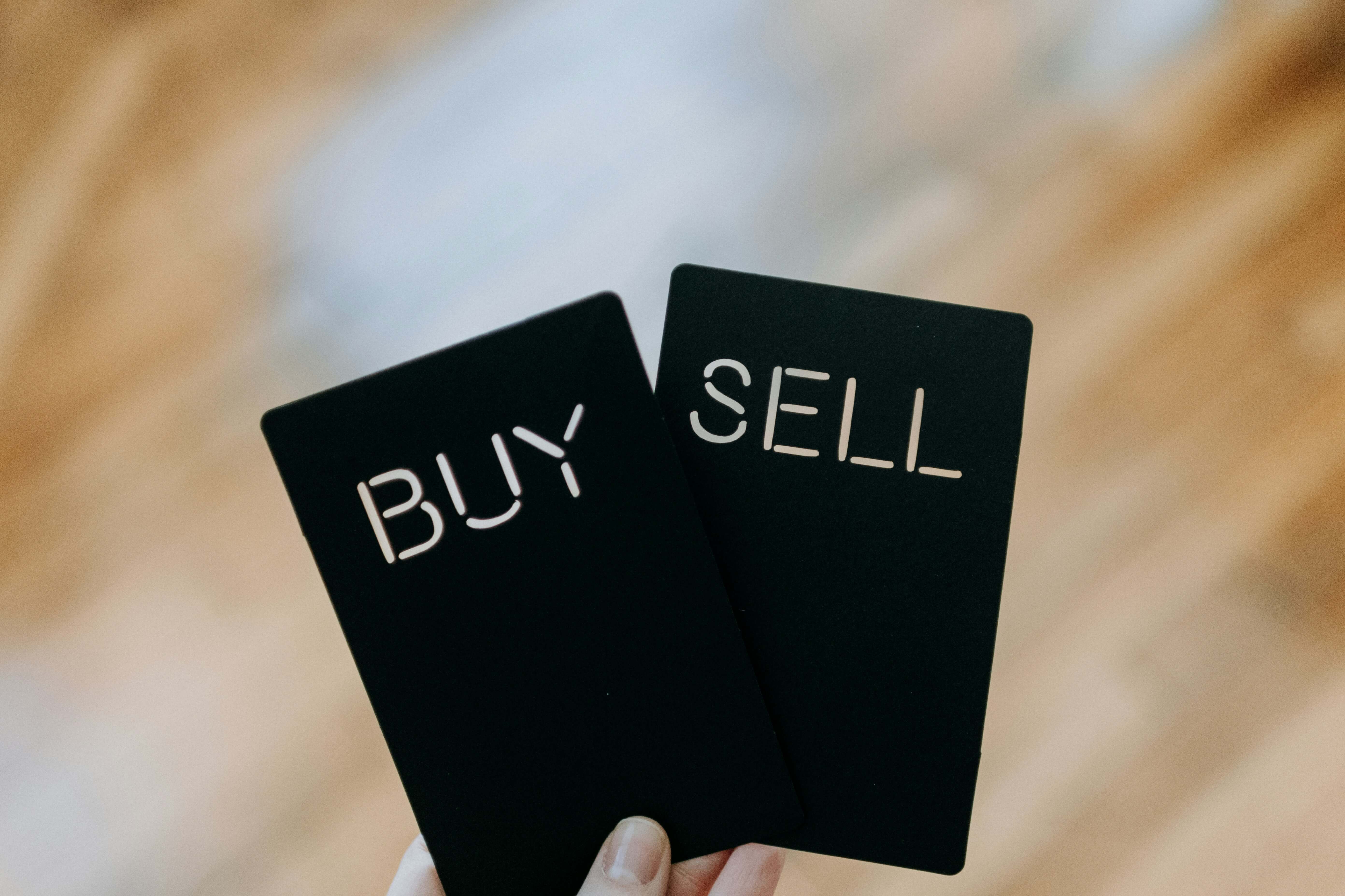 Someone holding buy and sell signs | Weathify.com