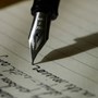 Close up photograph of a fountain pen with cursive writing.