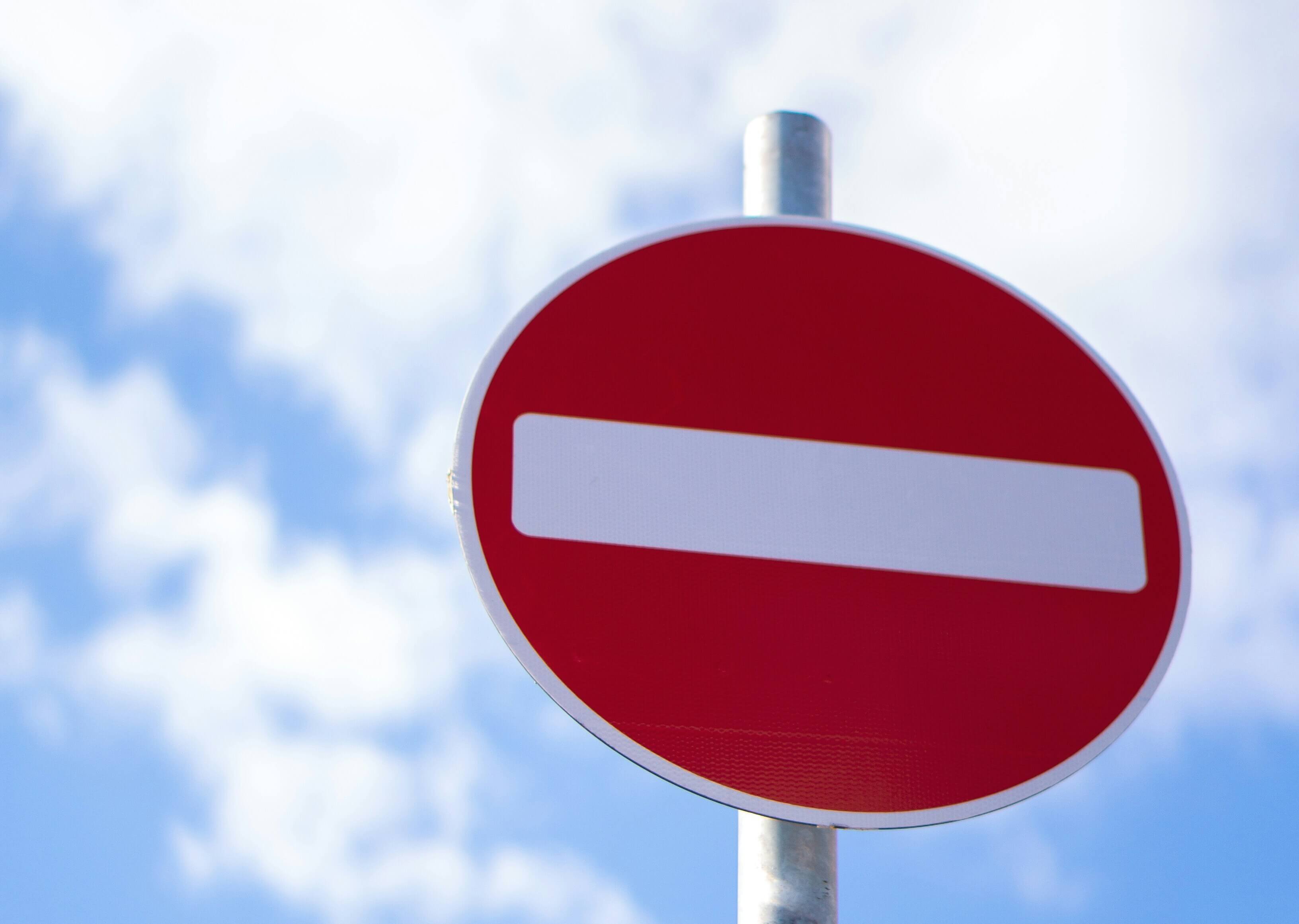 A stop sign with a blue sky and clouds in the background.