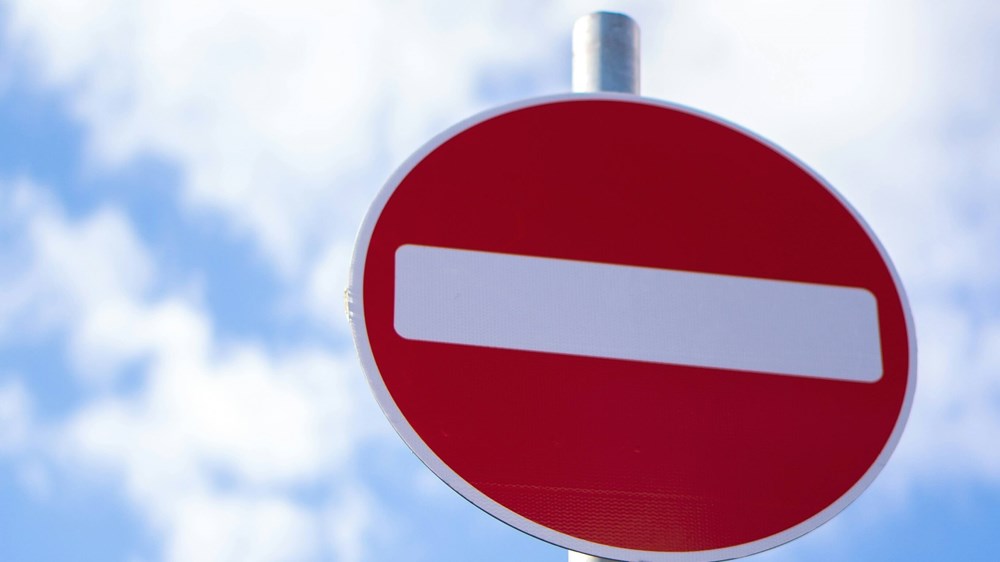 A stop sign with a blue sky and clouds in the background.