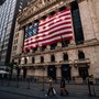 The New York Stock Exchange building with the US flag hanging over the large windows 